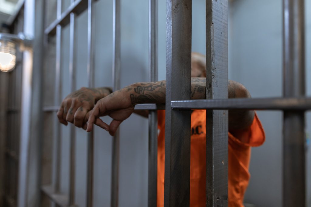 hand on bars of jail cell